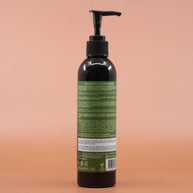 Das Haarpflegeprodukt AS I AM Rosemary Conditioner 237ml in der Rückansicht vor einem braun-orangen Hintergrund.