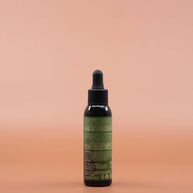 Das Haarpflegeprodukt AS I AM Rosemary Oil 60ml in der Rückansicht vor einem braun-orangen Hintergrund.
