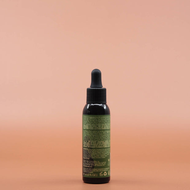 Das Haarpflegeprodukt AS I AM Rosemary Oil 60ml in der Rückansicht vor einem braun-orangen Hintergrund.