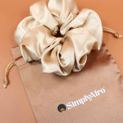 Afro Scrunchie Satin Beige liegend auf einem braunen SimplyAfro Säckchen