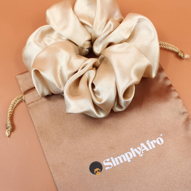 Afro Scrunchie Satin Beige liegend auf einem braunen SimplyAfro Säckchen