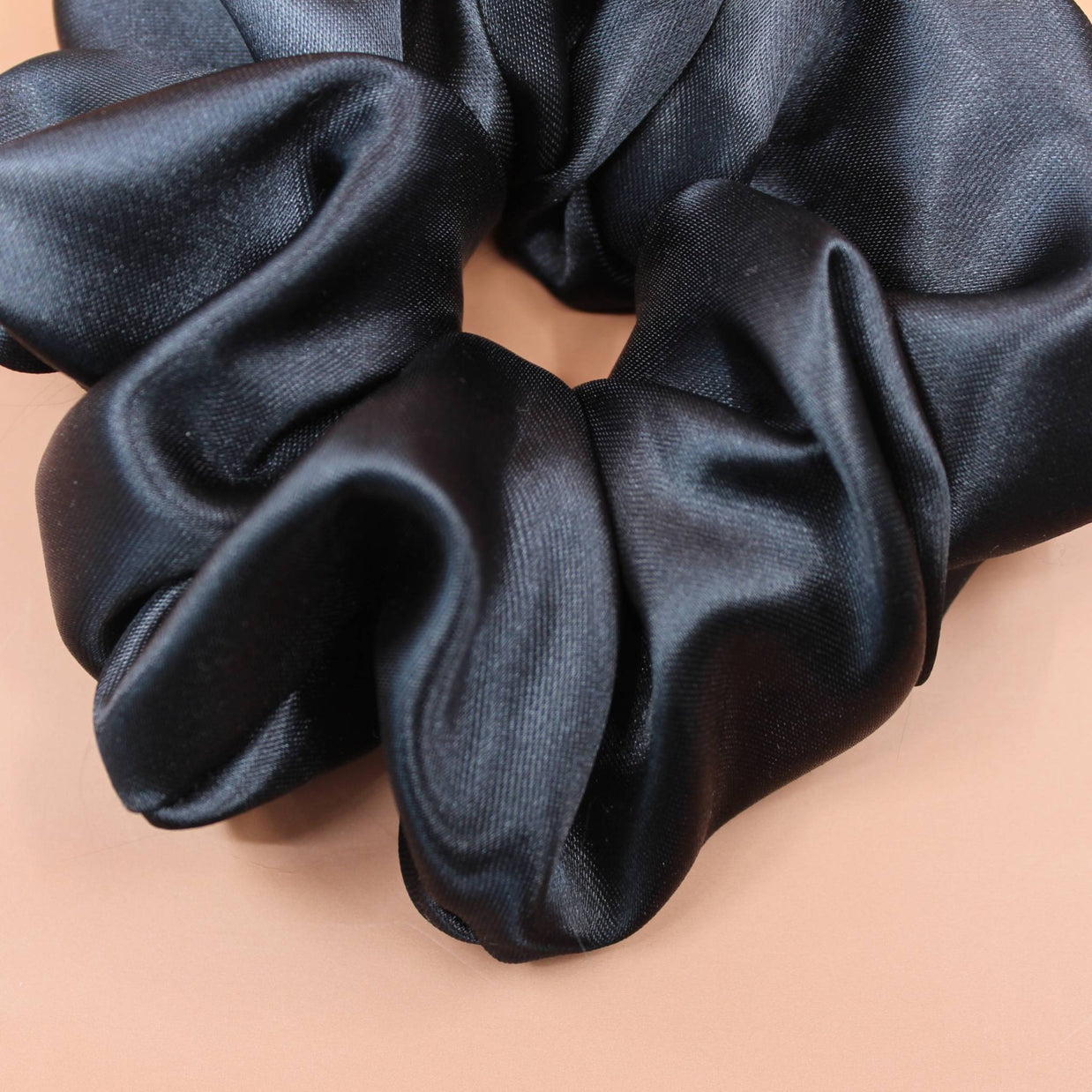 Afro Scrunchie Satin Schwarz liegend Nahaufnahme