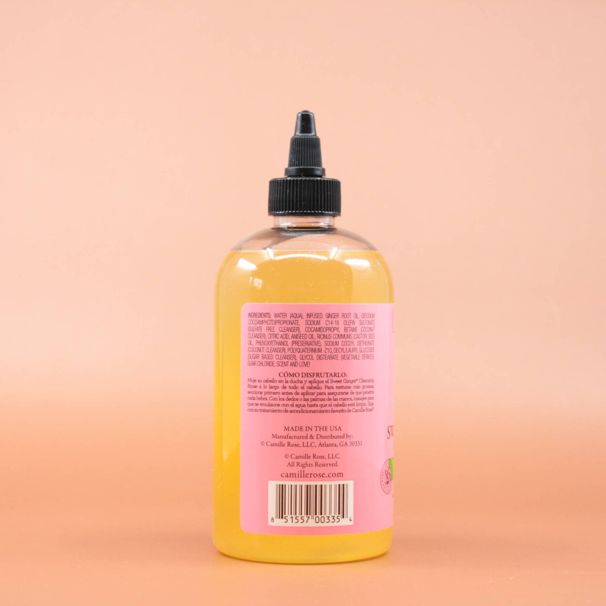 Das Haarpflegeprodukt CAMILLE ROSE Sweet Ginger Cleansing Rinse Shampoo 355ml in der Rückansicht vor einem braun-orangen Hintergrund.