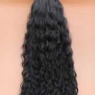DREAM HAIR Ponytail Diborra Curly, Farbe 1B (schwarz) in der Vorderansicht vor einem braun-orangen Hintergrund.