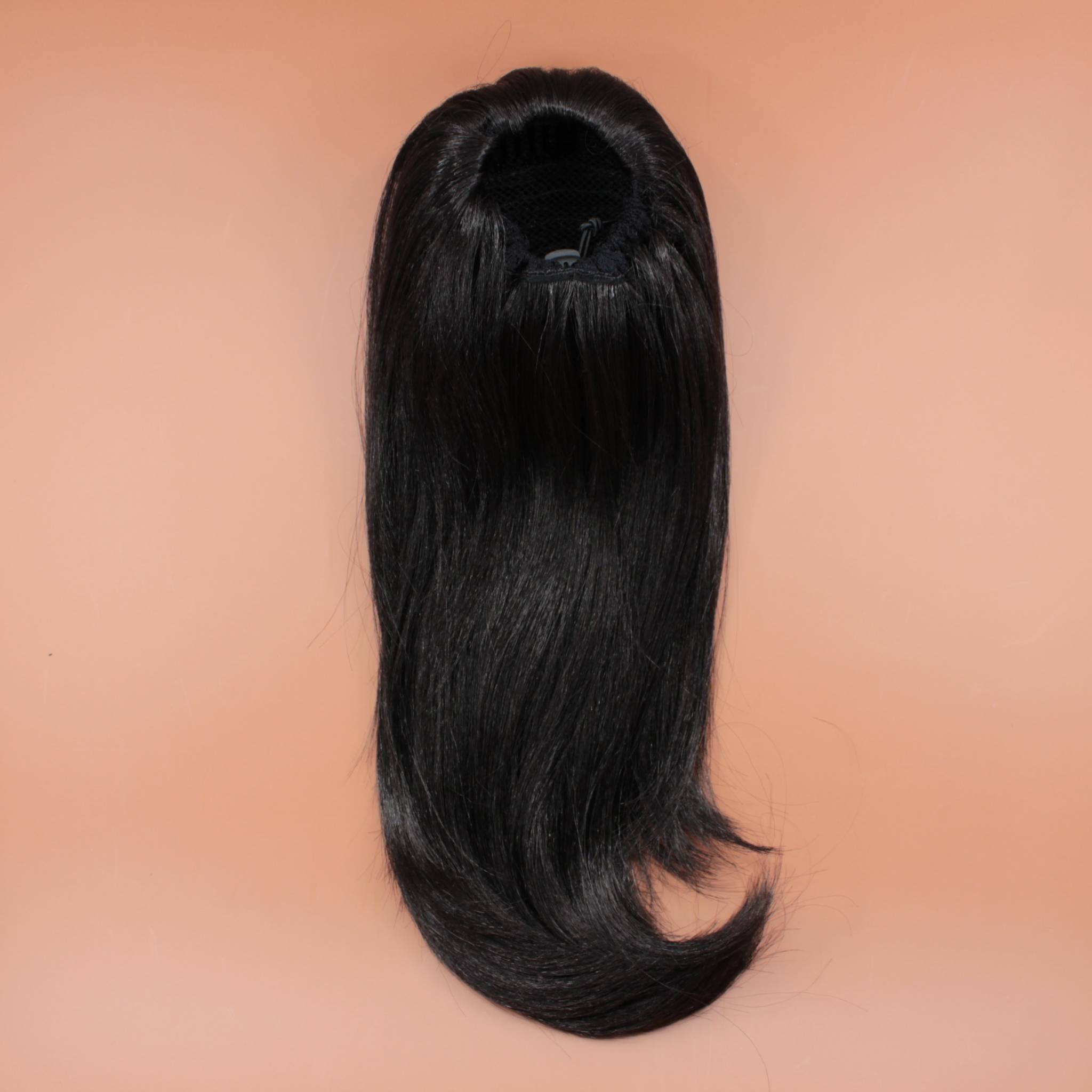 DREAM HAIR Ponytail Straight 14 inches, Farbe 1 (dunkelbraun) in der Rückansicht vor einem braun-orangen Hintergrund.