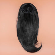 DREAM HAIR Ponytail Straight 14 inches, Farbe 1 (schwarz) in der Rückansicht vor einem braun-orangen Hintergrund.