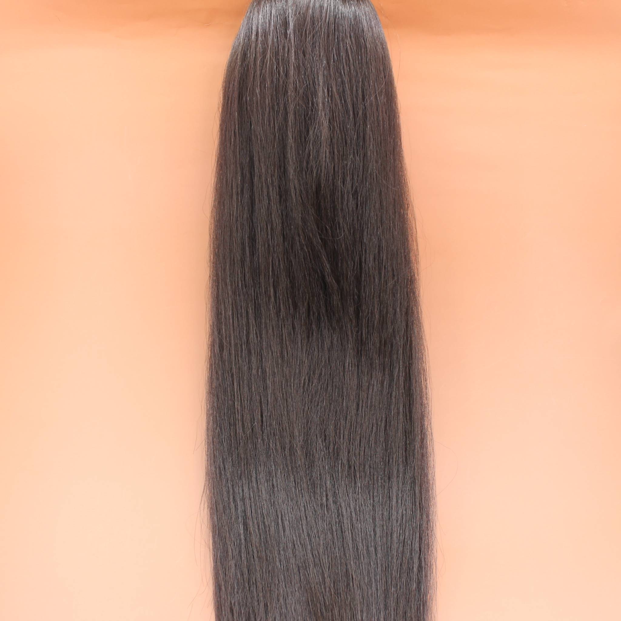 DREAM HAIR Ponytail Straight 30'', Farbe 4 (braun) in der Vorderansicht vor einem braun-orangen Hintergrund.