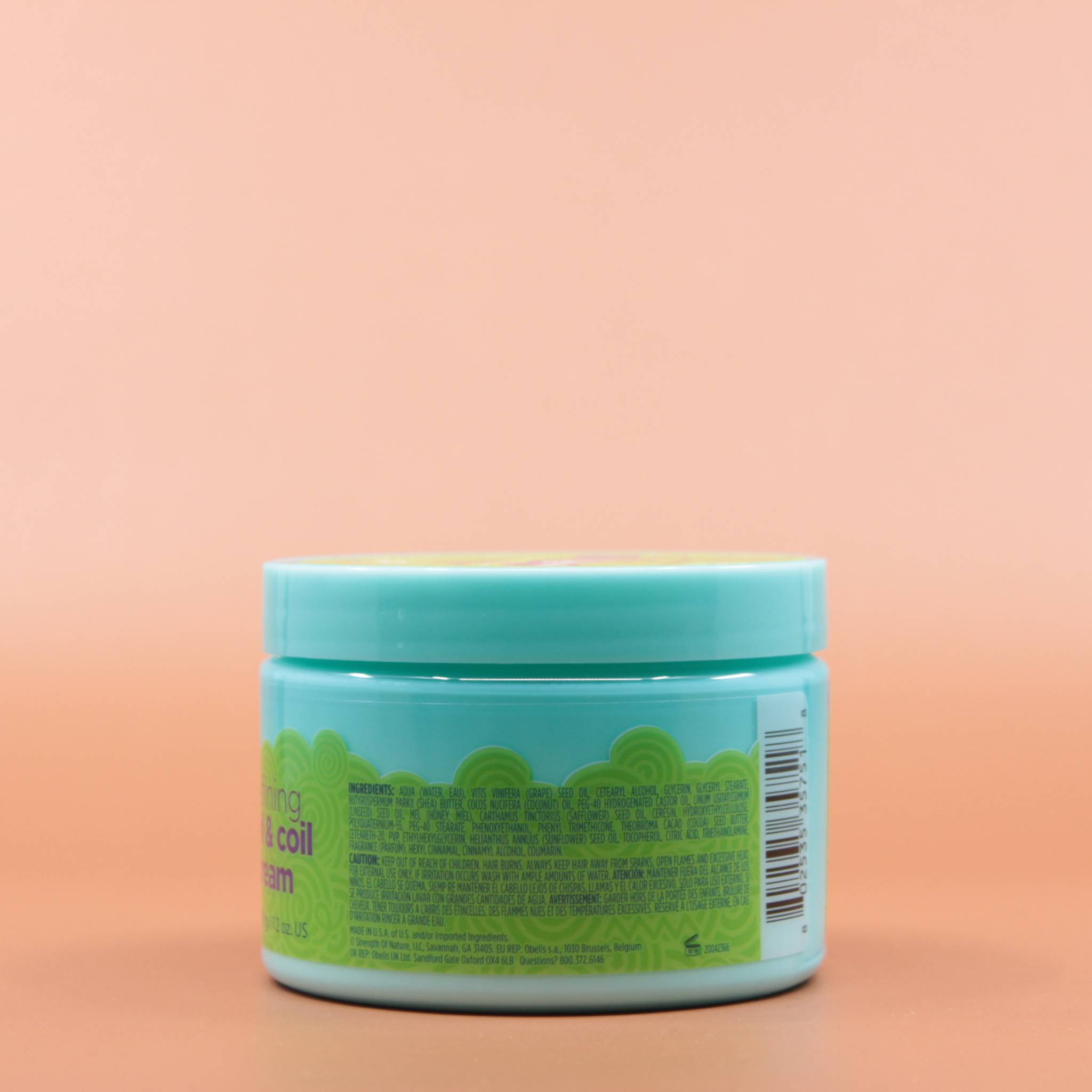 Das Kinder Haarpflegeprodukt JUST FOR ME Curl and Coil Cream Kids 340g in der Rückansicht vor einem braun-orangen Hintergrund.