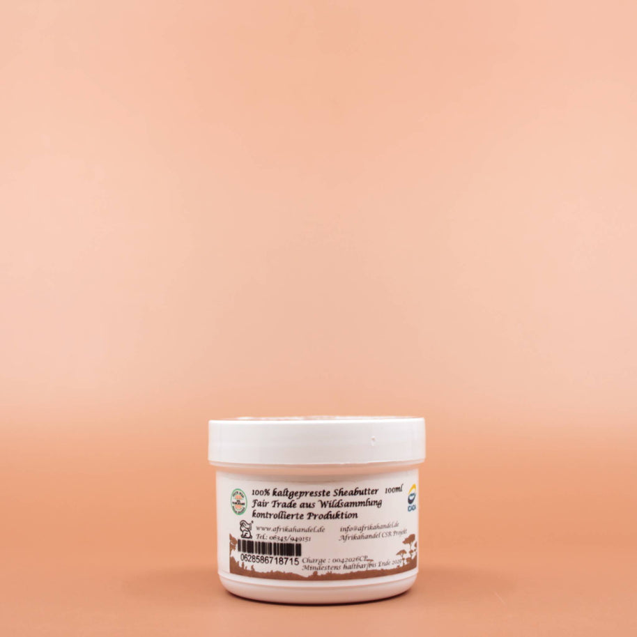 SHEA GOLD 100% Natural Fair Trade Bio Sheabutter 100ml in der Vorderansicht vor einem braun-orangen Hintergrund.