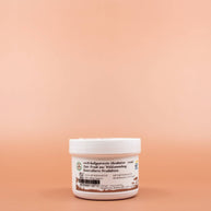 SHEA GOLD 100% Natural Fair Trade Bio Sheabutter 100ml in der Vorderansicht vor einem braun-orangen Hintergrund.