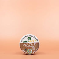SHEA GOLD 100% Natural Fair Trade Bio Sheabutter 100ml in der Draufsicht vor einem braun-orangen Hintergrund