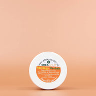 SHEA GOLD Moringa Baobab Sheabutter Creme 100ml Ansicht vom Deckel vor einem orange braunen Hintergrund 