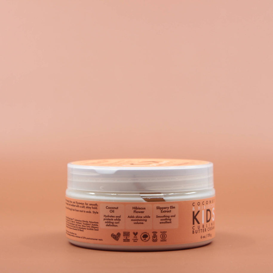 Das Kinder Haarpflegeprodukt SHEA MOISTURE Kids Curling Butter Cream 170g in der Seitenansicht (rechts) vor einem braun-orangen Hintergrund.